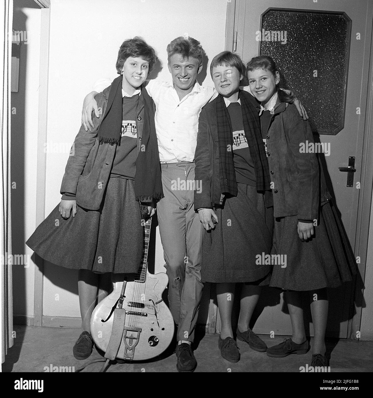 Tommy Steele. English entertainer regarded as Britain's first teen idol and rock and roll star. Born december 17 1936. Picture taken when he performed in Stockholm Sweden April 19 1958. Three fans has gotten the chance to meet with Tommy back stage. Stock Photo