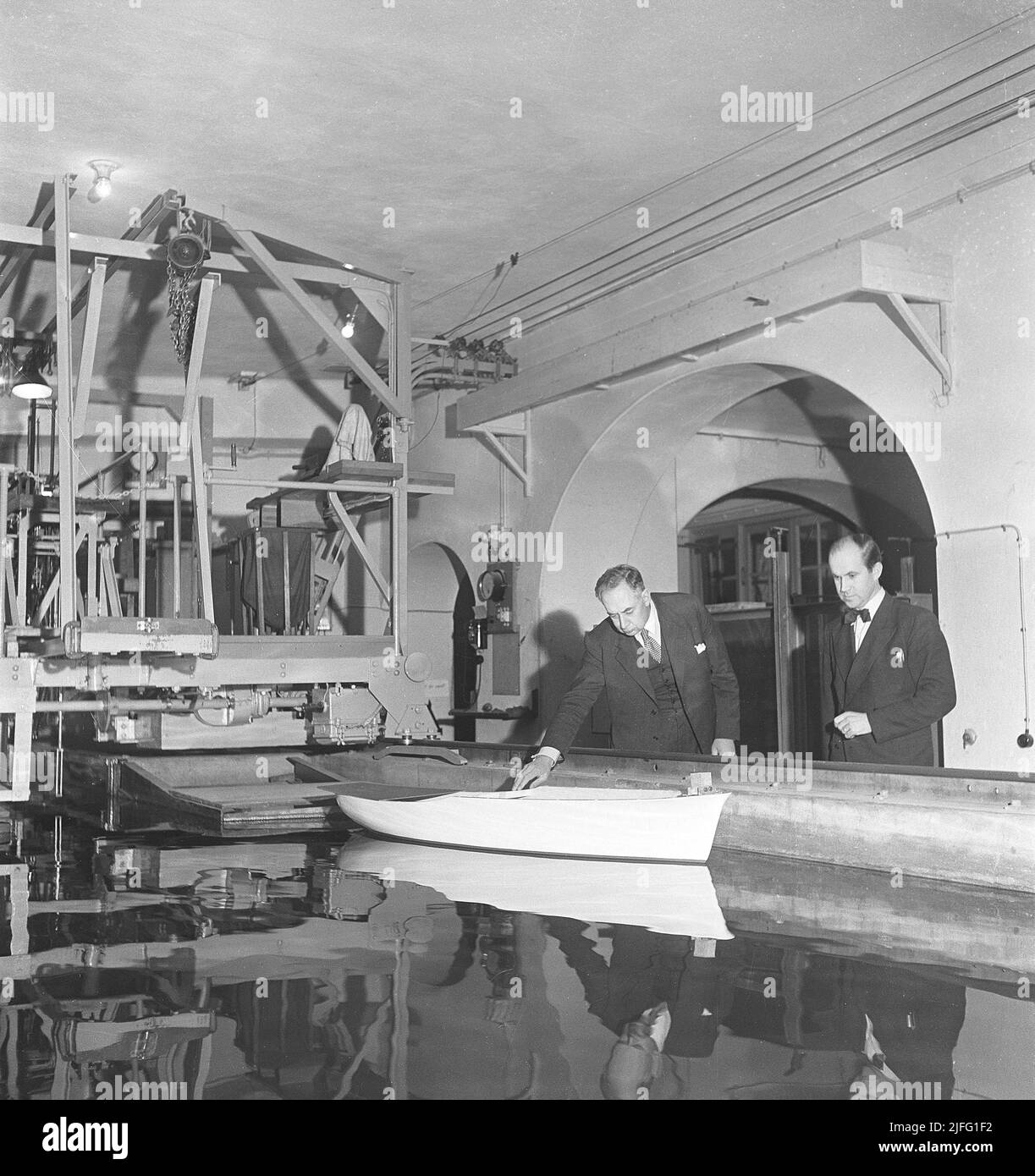 Ship engineering in the 1940s. A test is conducted of a shipmodel to simulate how it performs in the water, if the ship hull is of a good design or not. The test is among the first steps in shipbuilding and the results affects the safety, design, economics and overall performance of the ship to be built.  Sweden 1949 Kristoffersson ref AU51-3 Stock Photo