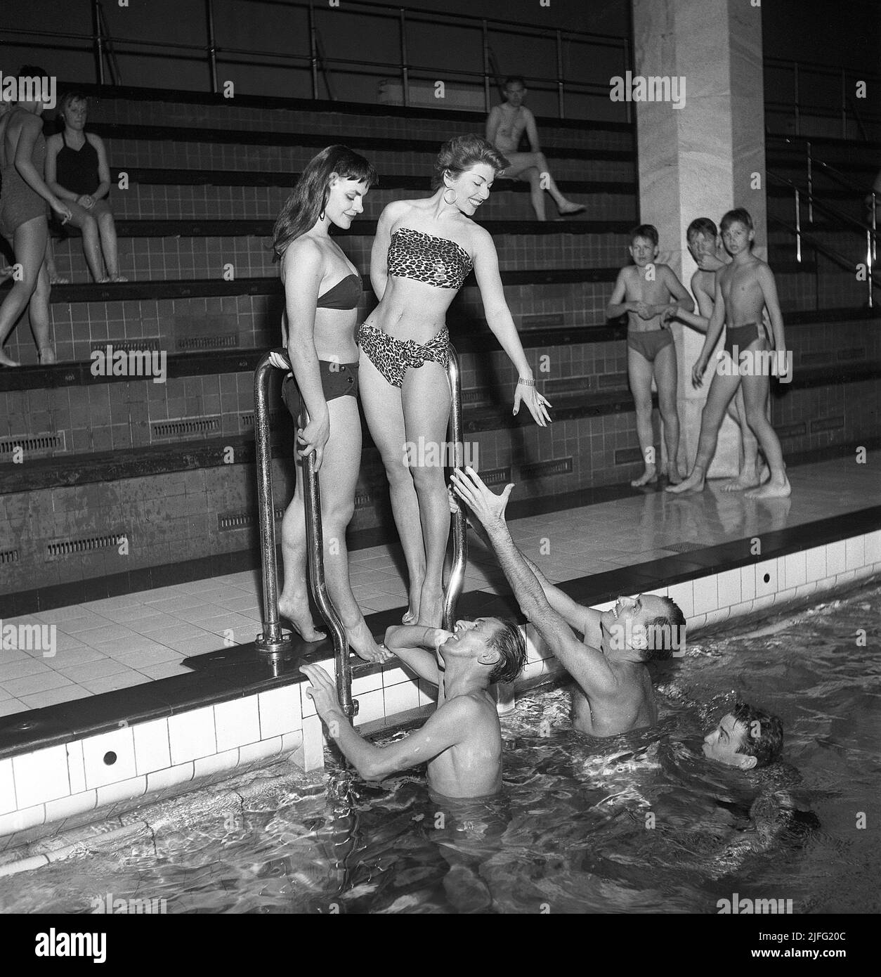 Swimming in the 1950s. A group of grownups are playing by the indoor swimmingpool. They are theatre and filmactors and actresses of the time.  Sweden 1953 Kristoffersson ref BM84-12 Stock Photo