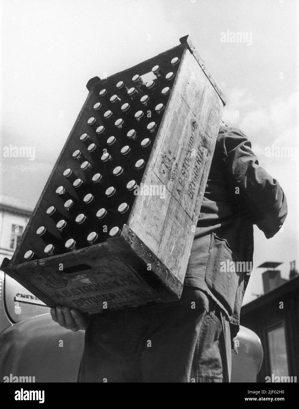 Beer history. A worker at the brewery Stockholms bryggerier carrying a wooden storage box with that contains 50 33 cl bottles of beer. The beer was distributed this way to stores and to restaurants. It was nicknamed 'Sofa'. Stockholsm bryggerier started in the 1870s and was a cooperation with other Stockholm breweries to create a monopoly to encrease prices of beer and to to achieve higher profitability. This monopoly lasted until the 1950s when the law prohibited breweries from having a cartel.  Sweden 1940s. Stock Photo