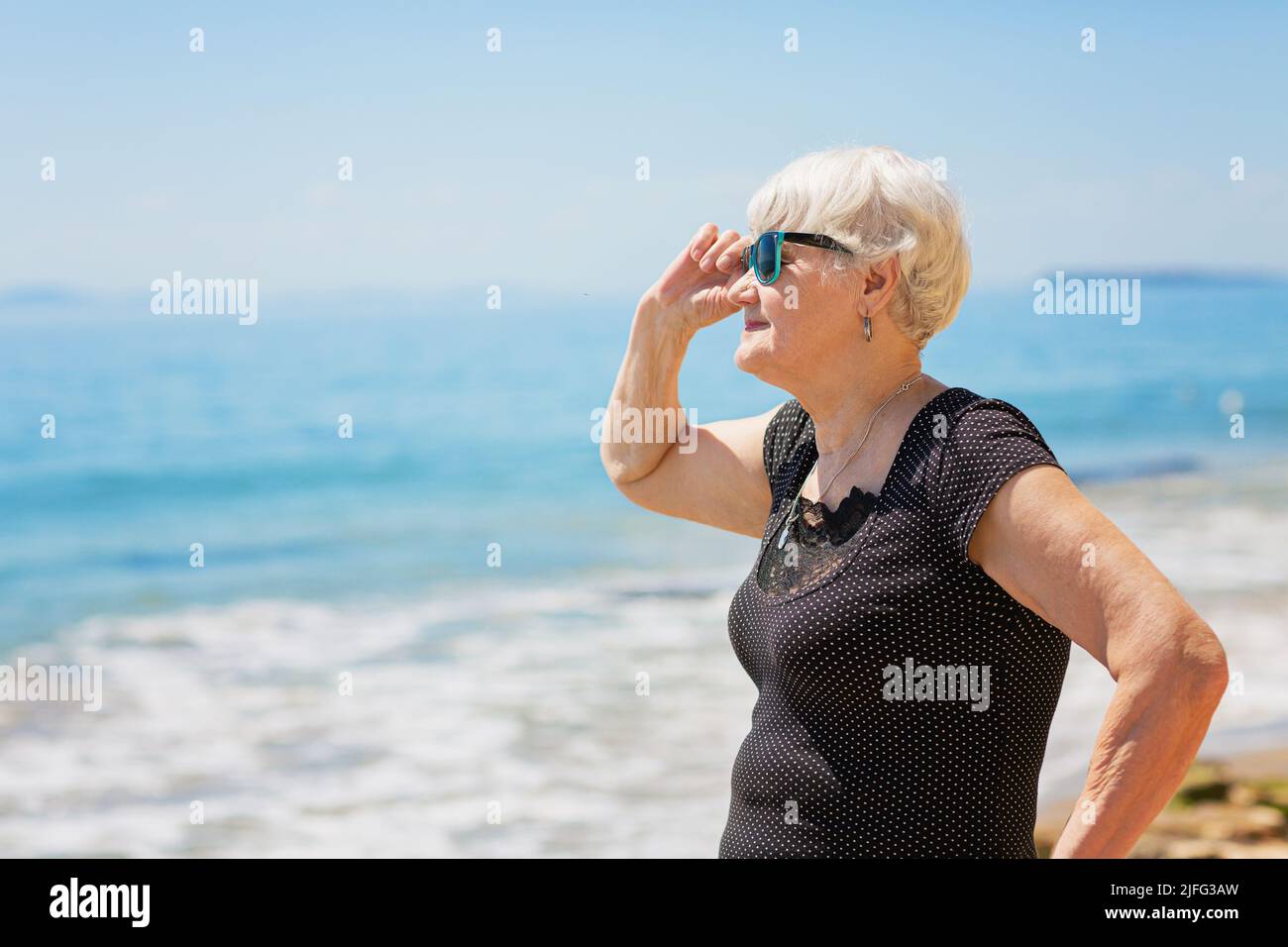 Senior woman of retirement age standing on the shore Stock Photo