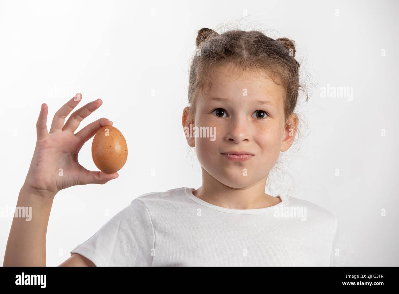Little girl holding one egg on white background Stock Photo Alamy