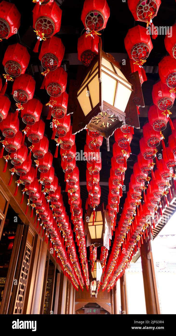A vertical shot of red Chinese lanterns hanging from the ceiling of a ...