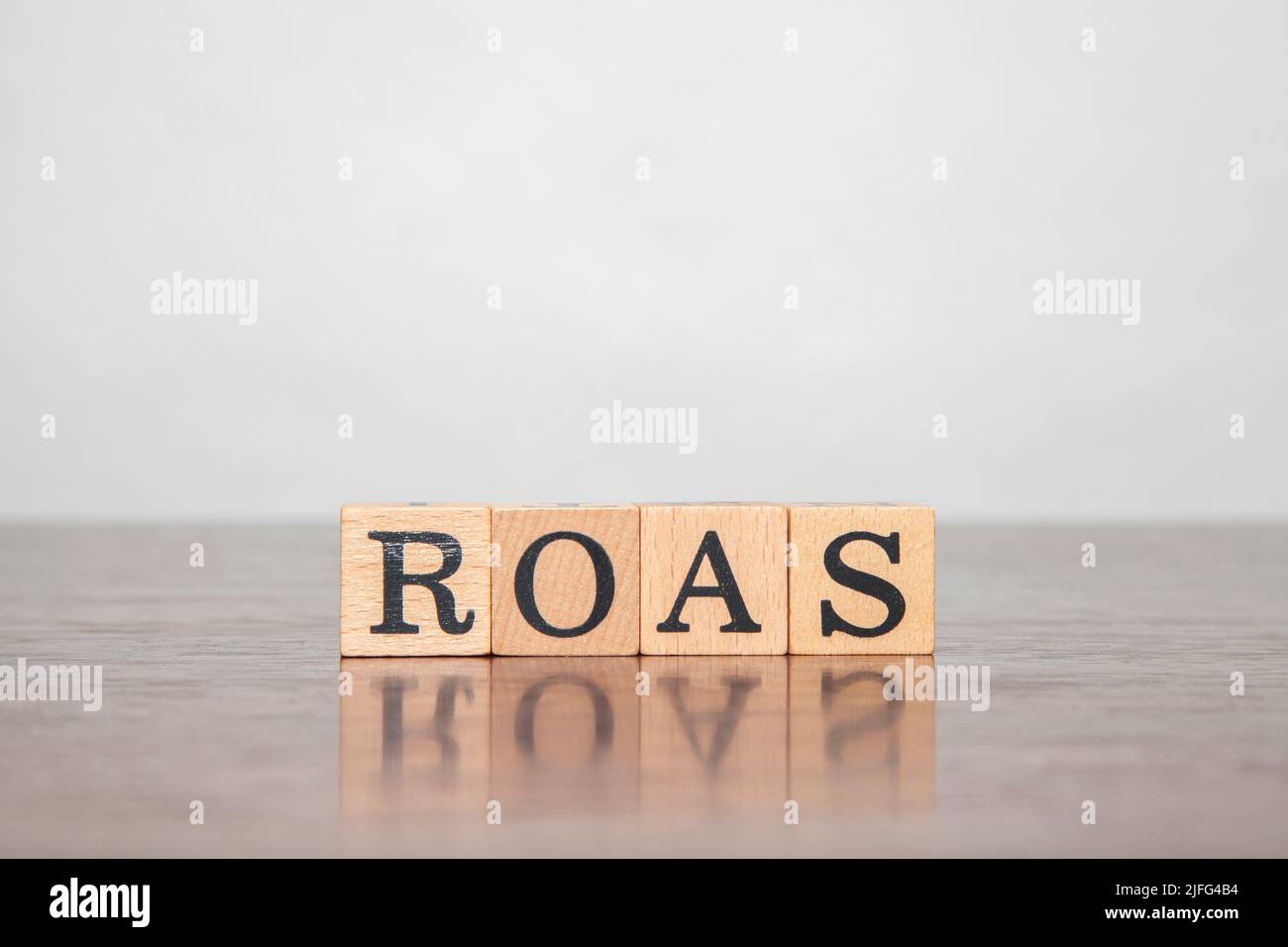 ROI character. Return on investment. Return On Investment. Written on three wooden blocks. Black letters. Wooden table background. Stock Photo