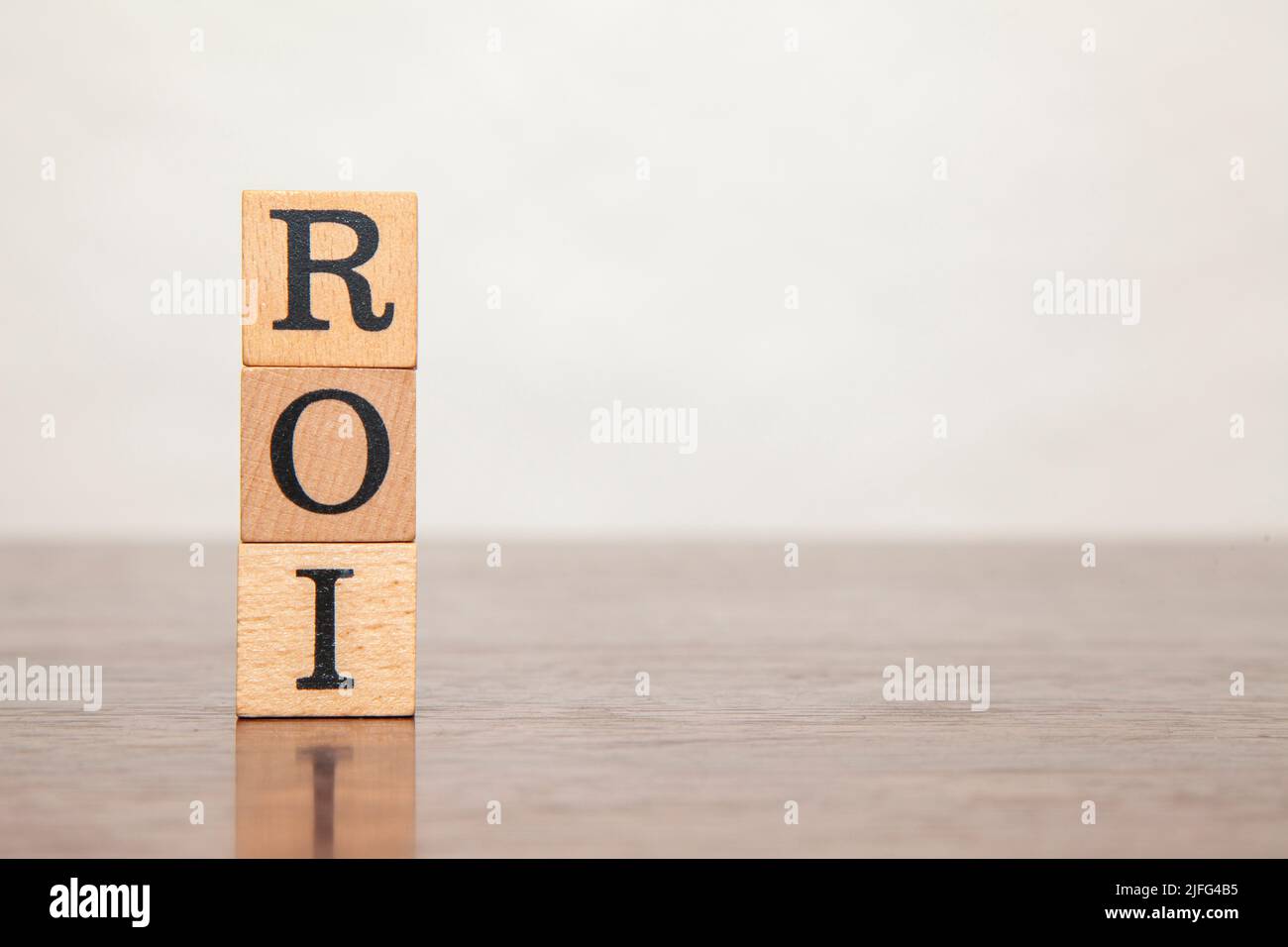 ROI character. Return on investment. Return On Investment. Written on three wooden blocks. Black letters. Wooden table background. Stock Photo