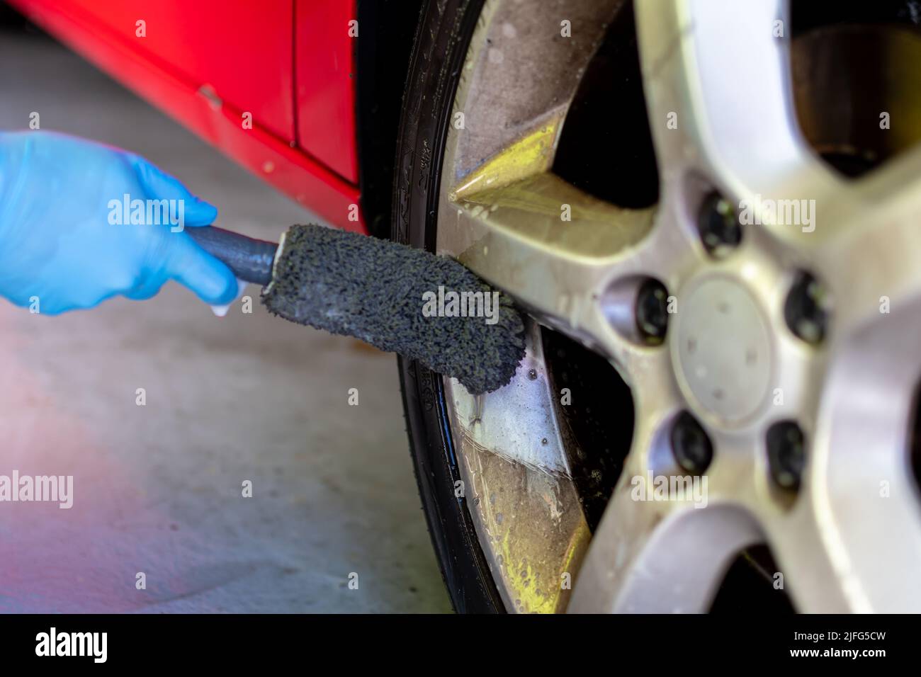 rubbing the wheel of the vehicle with a brush Stock Photo Alamy