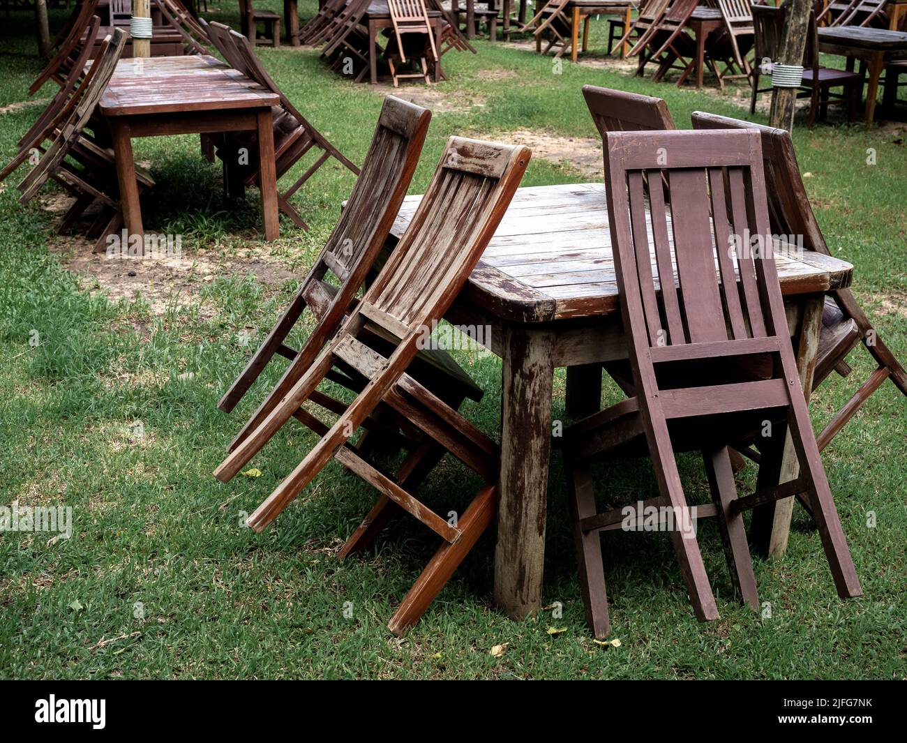 Empty old abandoned wooden dining table set on the green yard garden