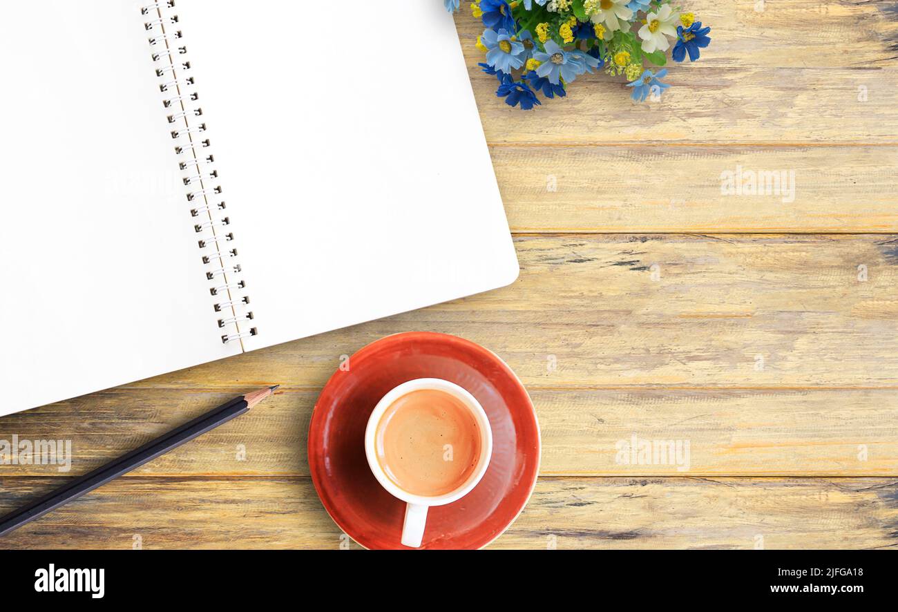 Top view image of blank notebook and cup of coffee on wooden table background Stock Photo