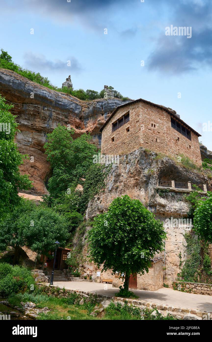 Stone house over a big rock close of a cliff at  Orbaneja del Castillo, Burgos, Spain, Europe Stock Photo