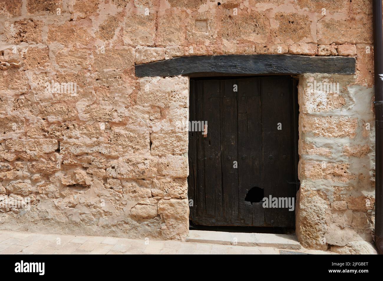 Stone facade with small old wooden door at little town of Orbaneja del Castillo, Burgos, Spain, Europe Stock Photo