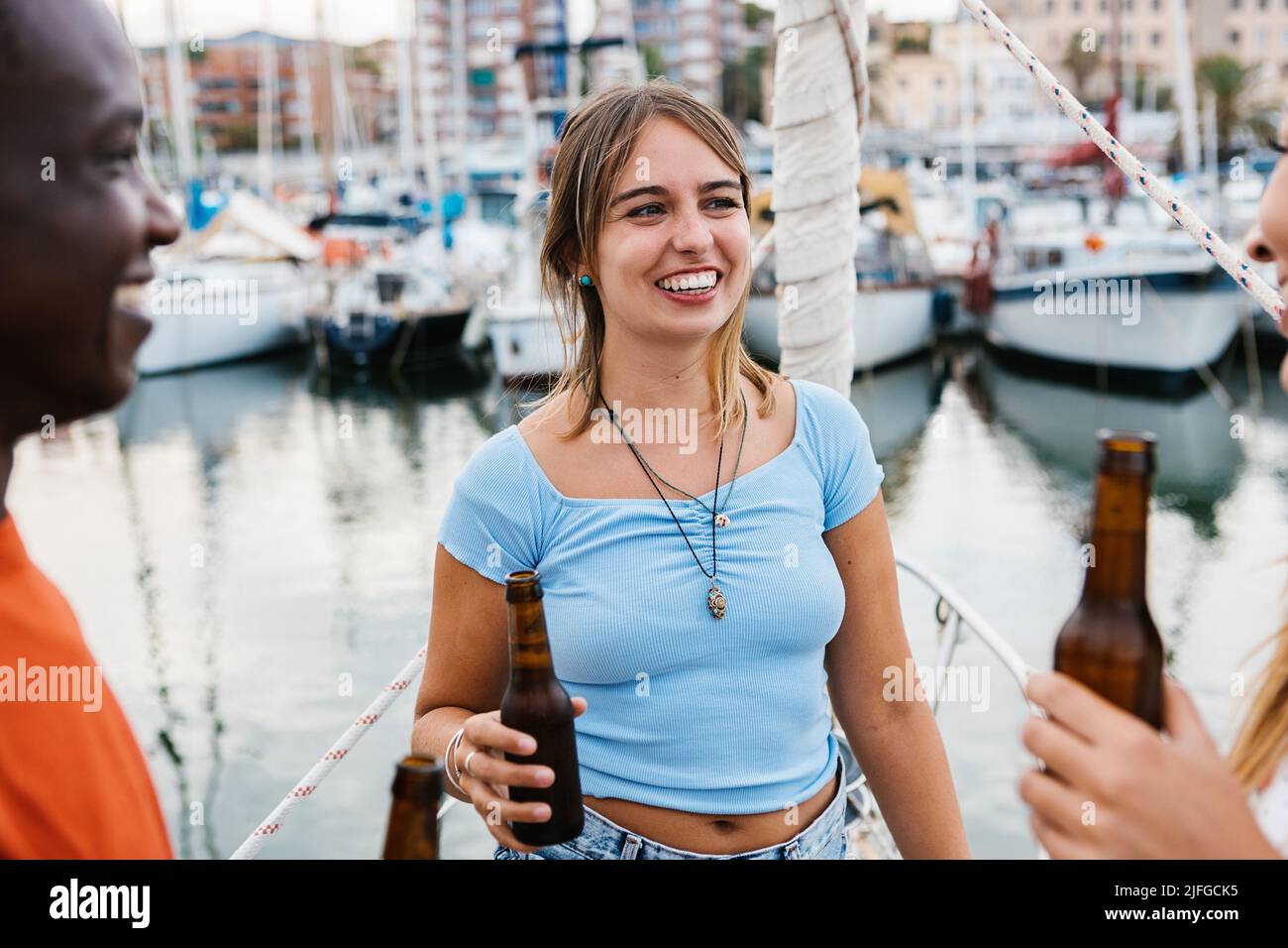 Smiling caucasian young woman having fun with friends on party boat Stock Photo