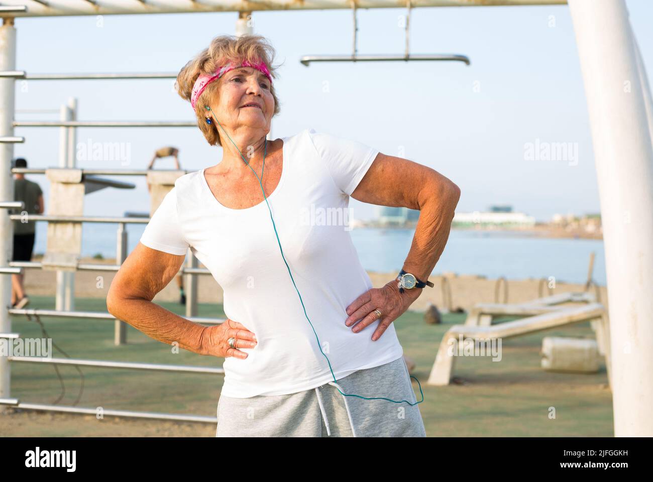 An elderly lady trains outdoors on the playground Stock Photo