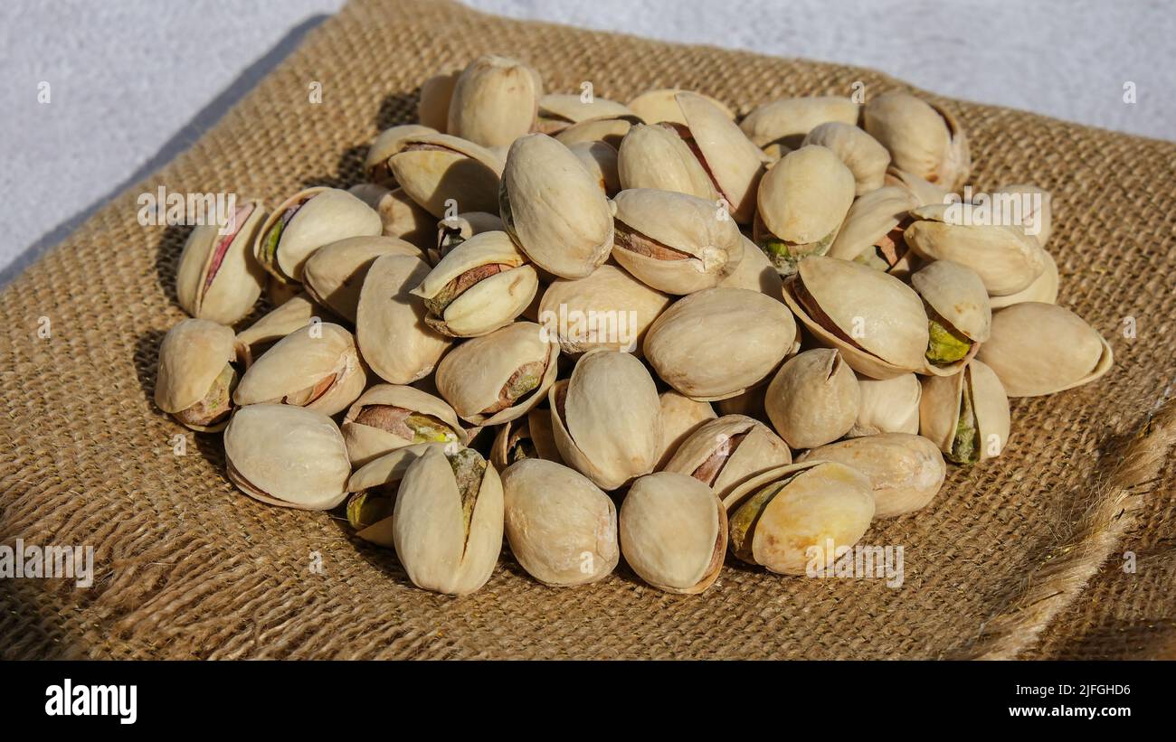 Pistachios in burlap sack on concrete table. Organic pistachios. Vegan