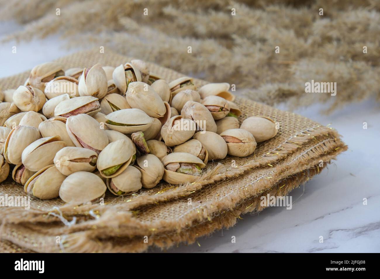 Pistachios in burlap sack on concrete table. Organic pistachios. Vegan