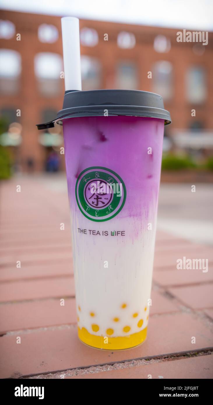 A vertical closeup of a cup with colorful bubble teas from the R&D tea