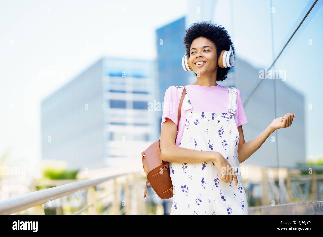 Content black woman listening to music in city Stock Photo