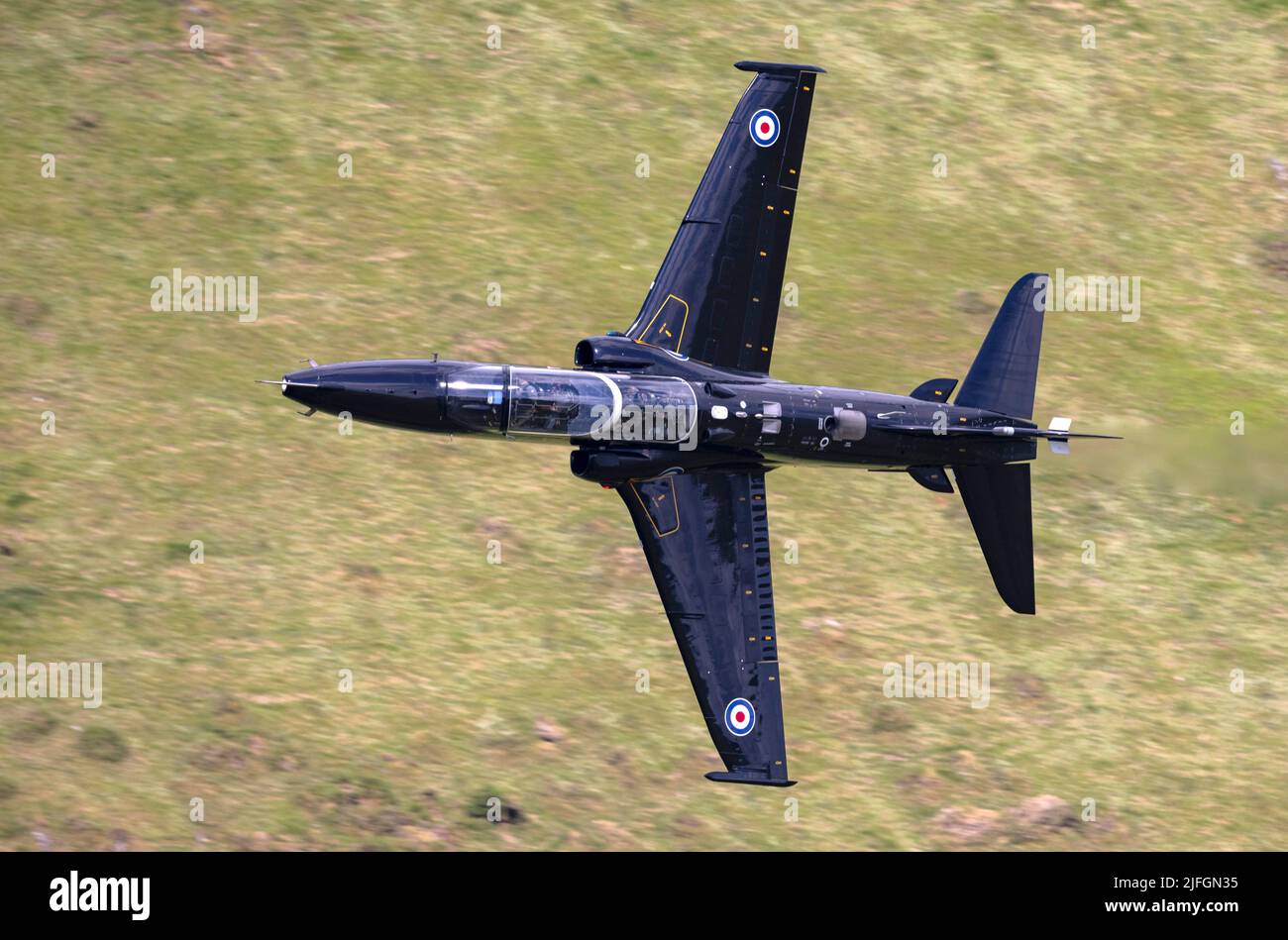 RAF Hawk T2 jet trainer, on a low level flying mission through the Welsh mountains/valleys of LFA7 Stock Photo