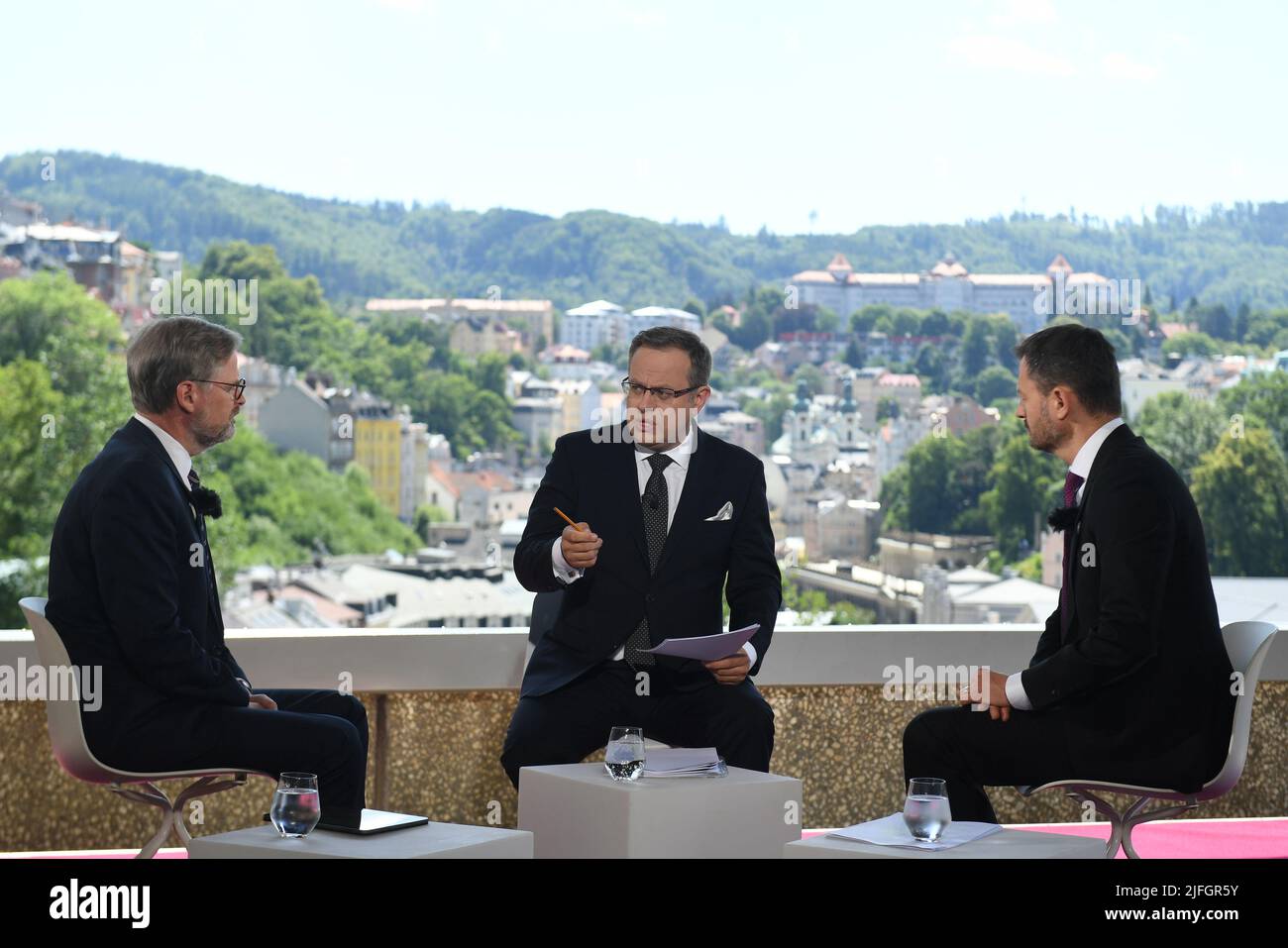 Karlovy Vary, Czech Republic. 03rd July, 2022. Czech Television's Question Time of Vaclav Moravec (centre) discussion programme, July 3rd, 2022, Karlovy Vary, Czech Republic. The guests of the first part were Czech Prime Minister Petr Fiala (left) and Slovak Prime Minister Eduard Heger. It can be presumed that Czech parliament will ratify the entry of Sweden and Finland to NATO in early autumn, PM Petr Fiala told Czech Television today. Fiala's Slovak counterpart Eduard Heger expects Slovakia to do the same soon, too. Credit: Katerina Sulova/CTK Photo/Alamy Live News Stock Photo