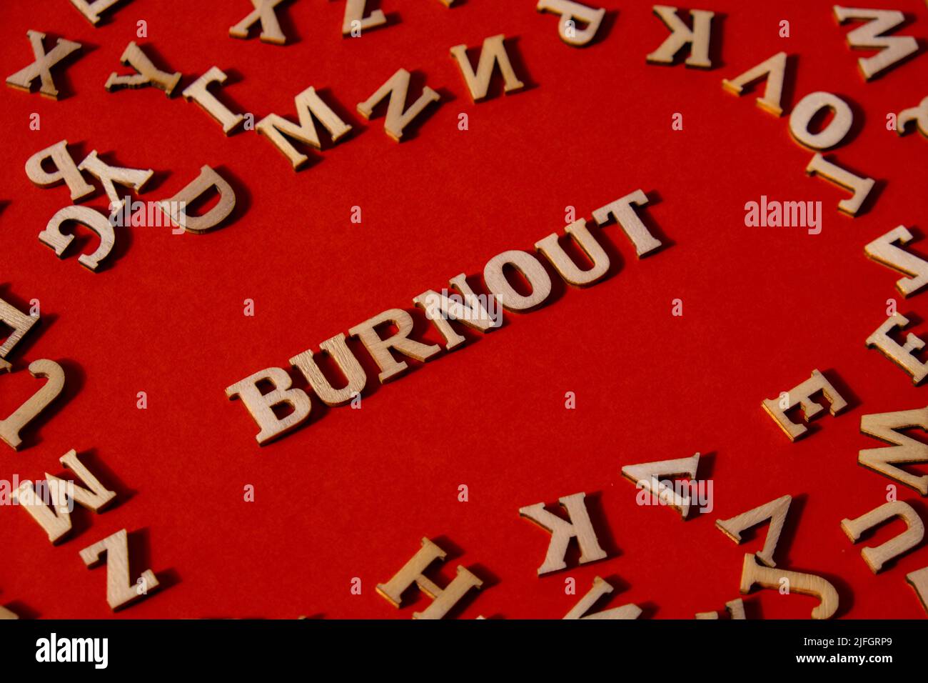 Word BURNOUT made out of wooden letters on bright red background