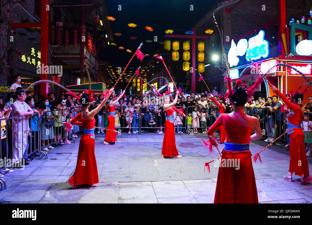 Chongqing. 1st June, 2022. People watch an art performance at a commercial street in southwest China's Chongqing Municipality, June 1, 2022. Under COVID-19 prevention and control measures, Chongqing in southwest China has striven to combine its night economy with culture and tourism in innovative ways, thus enhancing the vitality and attraction of nighttime consumption and turbocharging its development. Credit: Wang Quanchao/Xinhua/Alamy Live News Stock Photo
