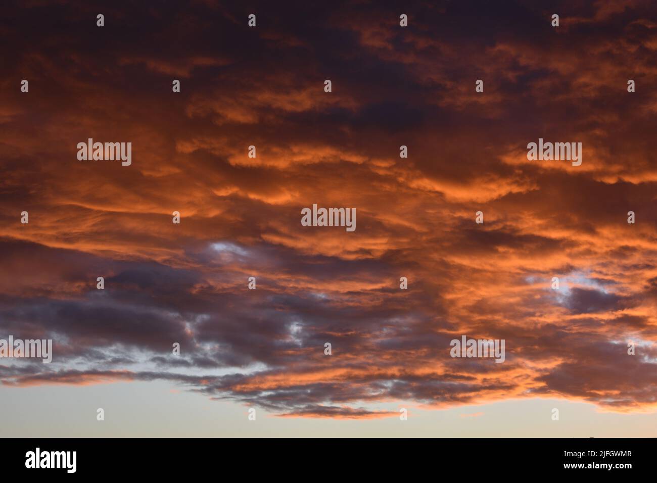 Black and orange dramatic skies as Nimbostratus clouds gather at sunset just before a Summer rain storm Stock Photo