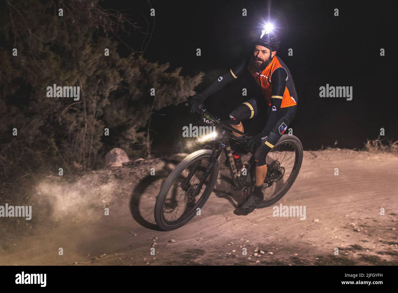 A Caucasian man riding a bike in a race held in the DFW metroplex in Texas at night Stock Photo