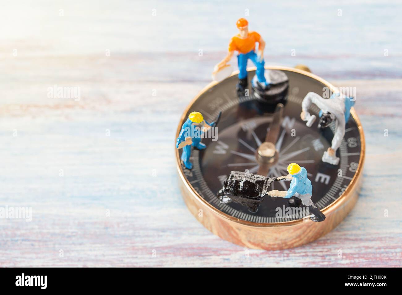 Miniature people- Figures construction worker, is working on a compass area with blurred background and sunlight.Business and construction concept Stock Photo