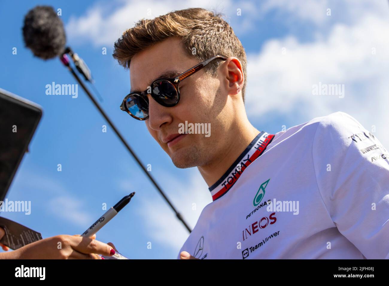 Silverstone, UK. 3rd July 2022, Silverstone Circuit, Silverstone, Northamptonshire, England: British F1 Grand Prix, Race day: Mercedes-AMG Petronas F1 Team driver George Russell signs an autograph Credit: Action Plus Sports Images/Alamy Live News Stock Photo