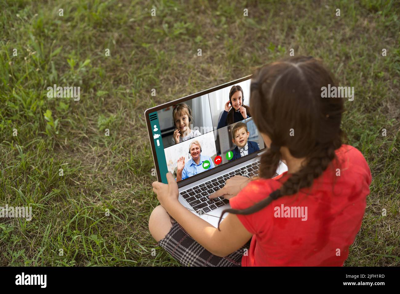 little girl learns, a teenager working on laptop lying on a meadow