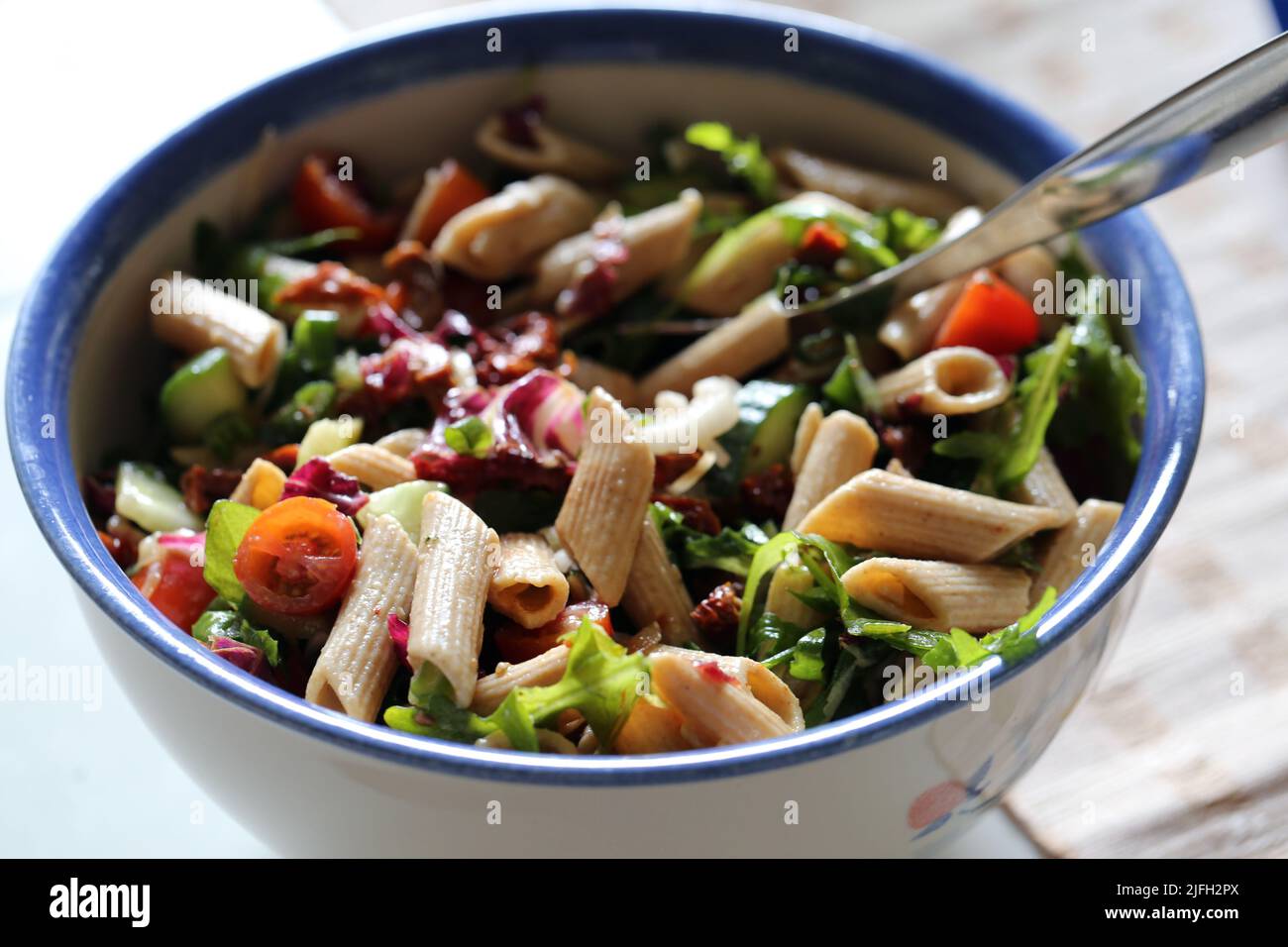 Homemade delicious pasta salad with some pasta and different vegetables. DIY healthy food in a bowl on a table in a Finnish summer cottage, eating out Stock Photo