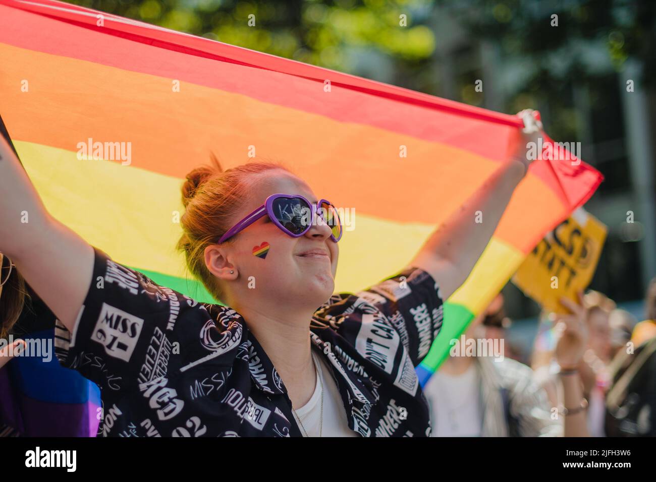Cologne, Germany. 03rd July, 2022. A woman with a rainbow flag takes part in a Christopher Street Day (CSD) parade. Hundreds of thousands of spectators are expected to attend the demonstration. The Cologne CSD is one of the largest events of the LGBTIQ community in Europe. Credit: Marius Becker/dpa/Alamy Live News Stock Photo
