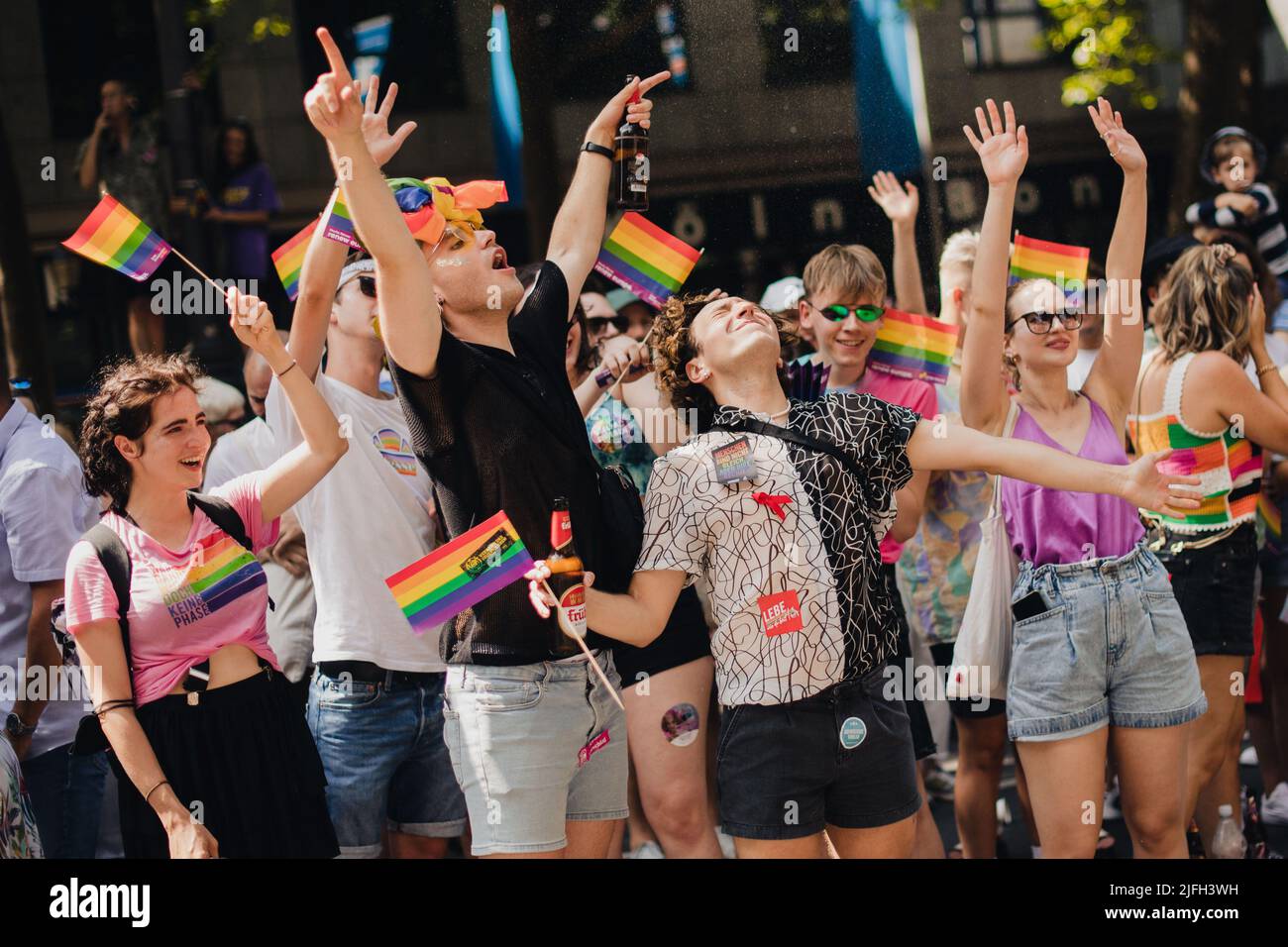 Cologne, Germany. 03rd July, 2022. Spectators at a Christopher Street Day (CSD) parade cheer as they are splashed with water. Hundreds of thousands of spectators are expected to attend the demonstration. The Cologne CSD is one of the largest events of the LGBTIQ community in Europe. Credit: Marius Becker/dpa/Alamy Live News Stock Photo