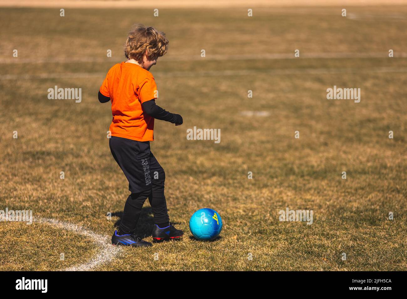 A young boy is getting ready to hit the ball. Youth Spring Soccer Games