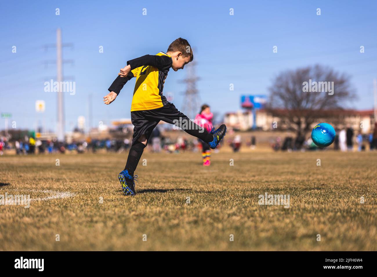 A young boy kicking the ball on soccer field. Spring Soccer Games in