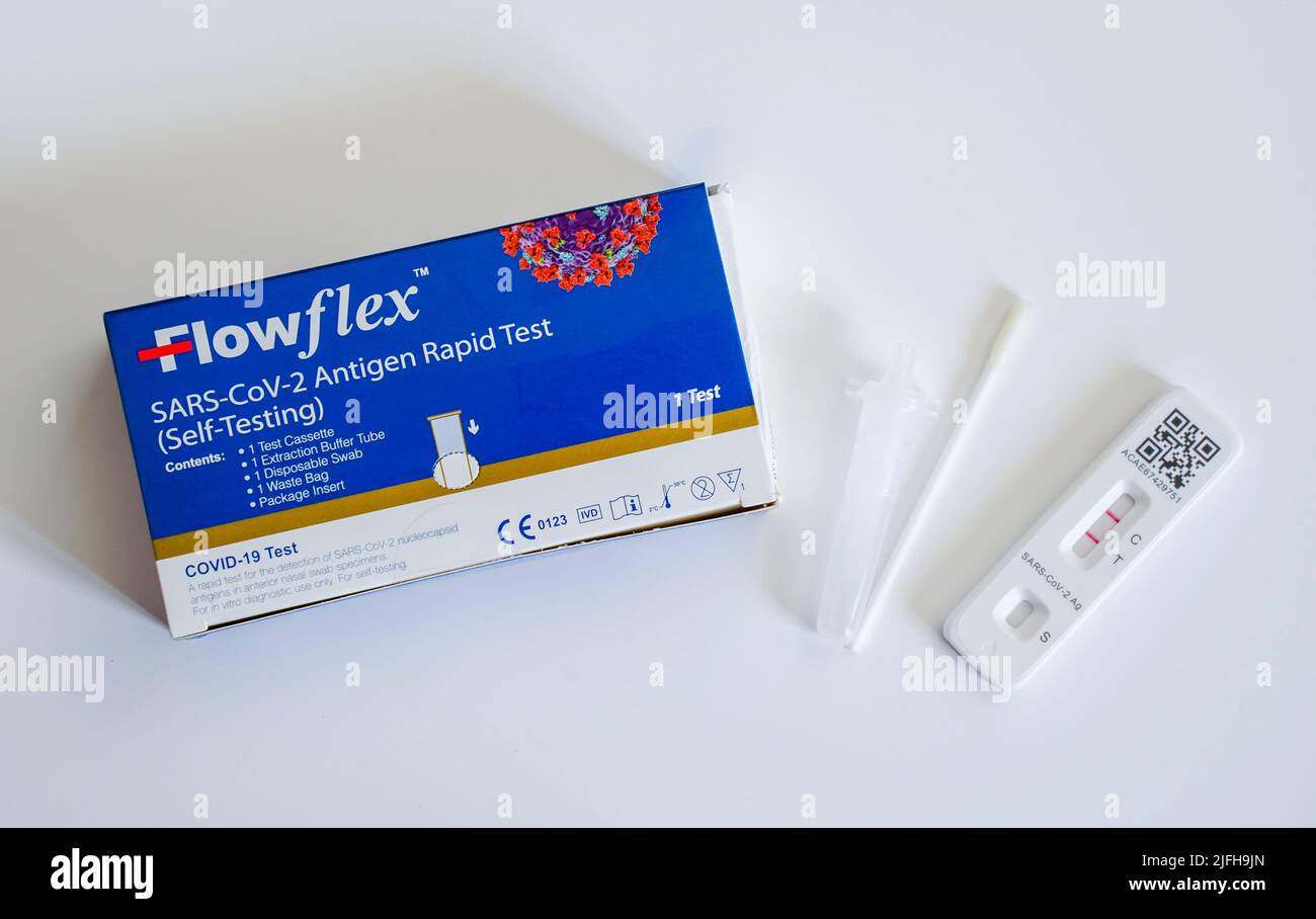 Flowflex Covid-19 rapid test, antigen test, Home test next to swab showing positive (two lines) result on test card. Stock Photo