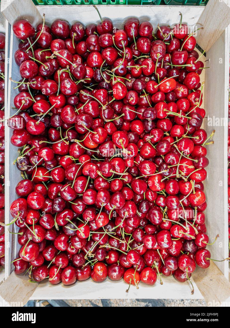 Red and rainier cherries in a rustic box. Stock Photo