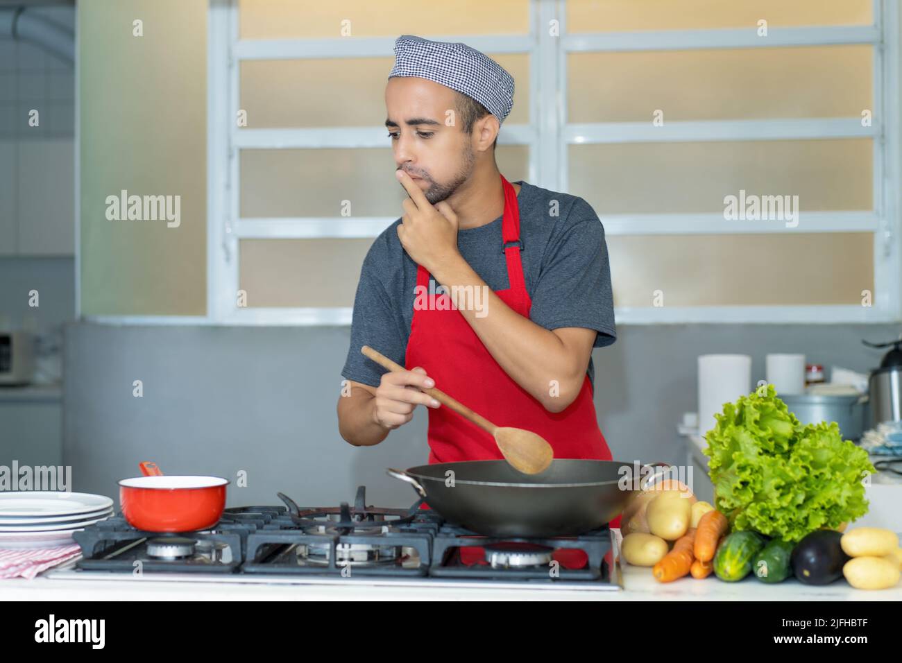 Latin american chef with apron at work at kitchen of restaurant Stock Photo