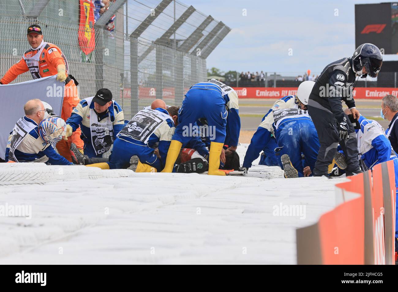 Silverstone, UK. 3rd July 2022, Silverstone Circuit, Silverstone, Northamptonshire, England: British F1 Grand Prix, Race day: Alfa Romeo F1 Team Orlen, Guanyu Zhou gets removed of the car by doctors Credit: Action Plus Sports Images/Alamy Live News Stock Photo