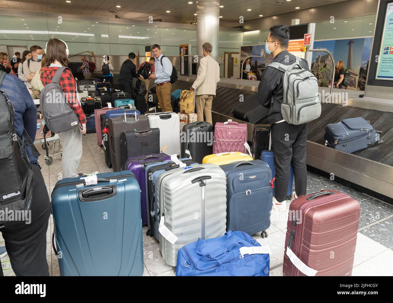 Heathrow airport delays; people searching through piles of baggage due to disruption, Terminal 3 baggage collection, London Heathrow UK Stock Photo