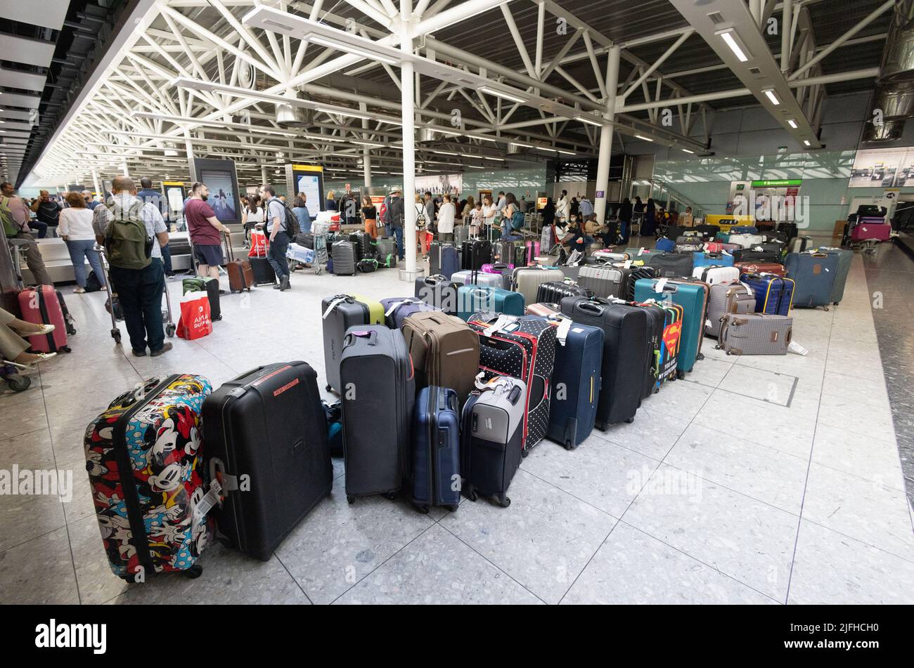 Heathrow airport travel disruption; Piles of baggage waiting uncollected in baggage collection, Terminal 3 interior delay, London airport UK; Stock Photo