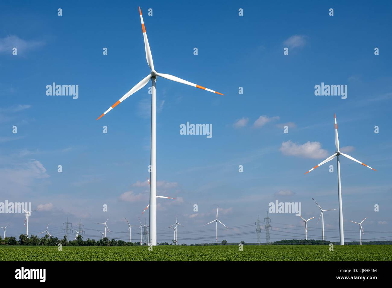 Wind turbines with power lines in the back seen in Germany Stock Photo