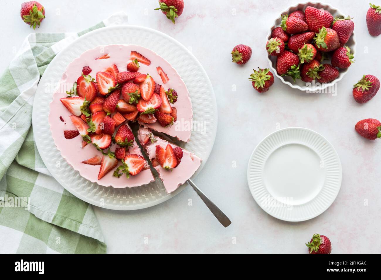 Sweet strawberry cheesecake with one slice cut out ready for serving