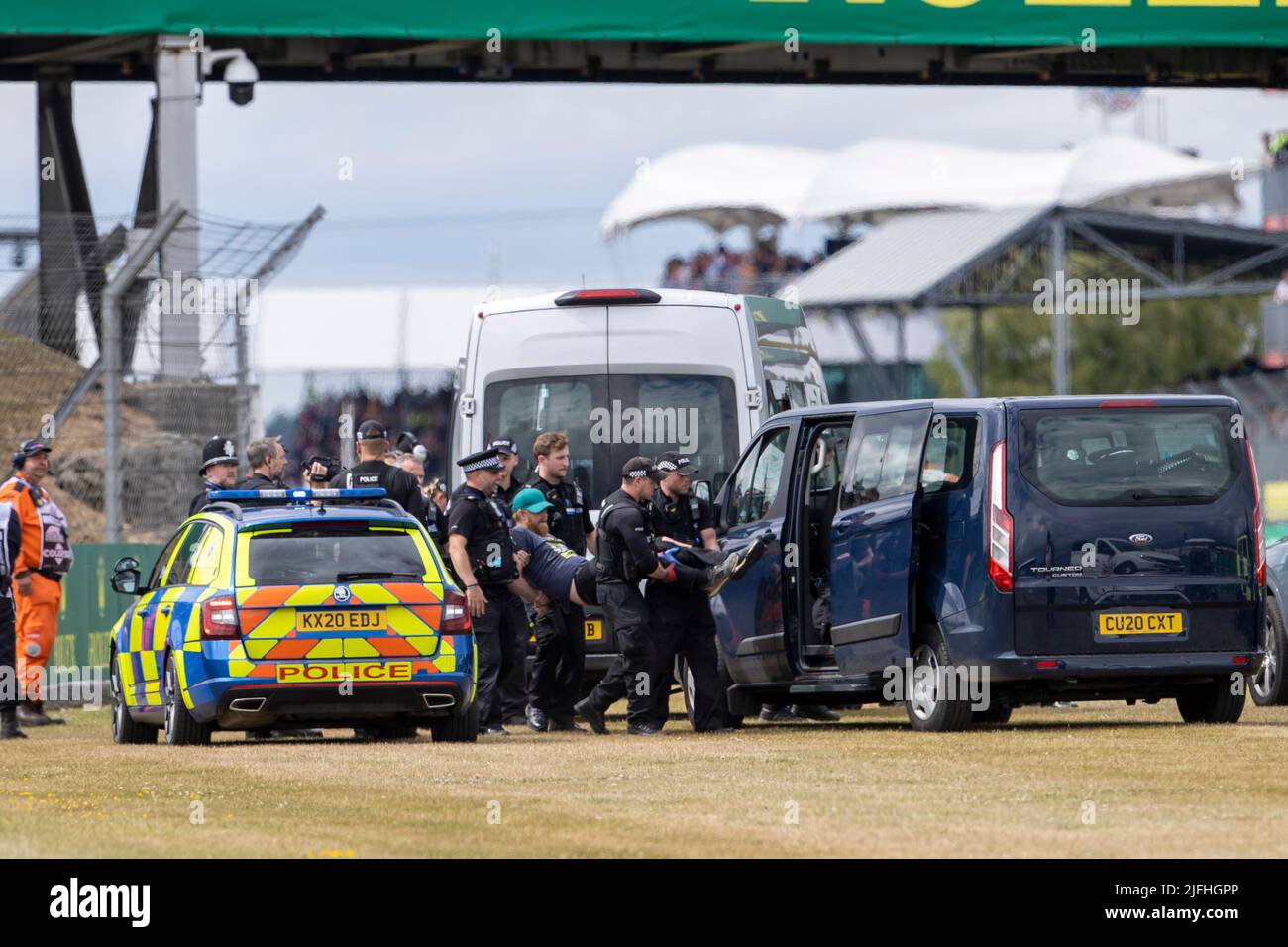 Silverstone, UK. 3rd July 2022, Silverstone Circuit, Silverstone, Northamptonshire, England: British F1 Grand Prix, Race day: A protester is loaded into a Police van after running onto the track on the opening lap Credit: Action Plus Sports Images/Alamy Live News Stock Photo
