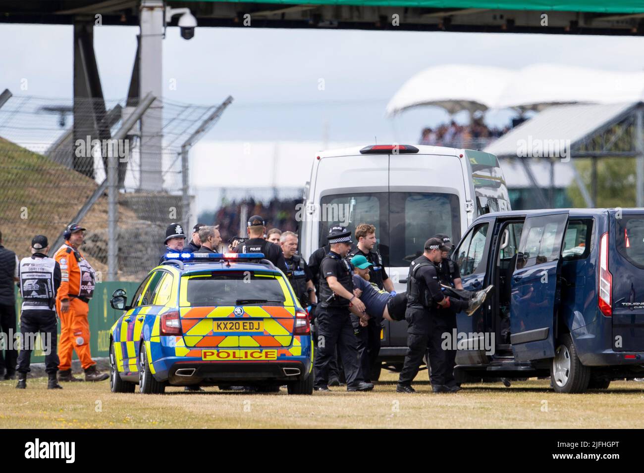 Silverstone, UK. 3rd July 2022,  Silverstone Circuit, Silverstone, Northamptonshire, England: British F1 Grand Prix, Race day: A protester is loaded into a Police van after running onto the track on the opening lap Credit: Action Plus Sports Images/Alamy Live News Stock Photo