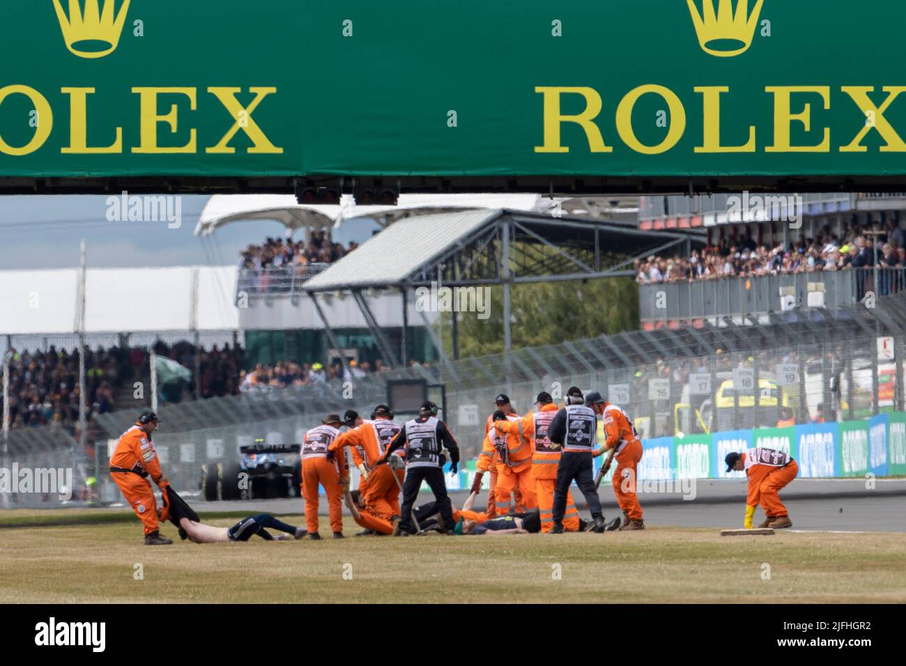 Silverstone, UK. 3rd July 2022,  Silverstone Circuit, Silverstone, Northamptonshire, England: British F1 Grand Prix, Race day: Protestors are removed after running onto the track on the opening lap Credit: Action Plus Sports Images/Alamy Live News Stock Photo