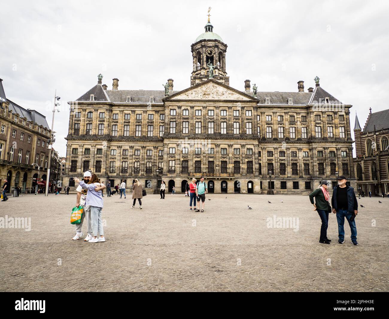 Tourists in front of the Royal palace on Dam Square, Amsterdam Stock Photo