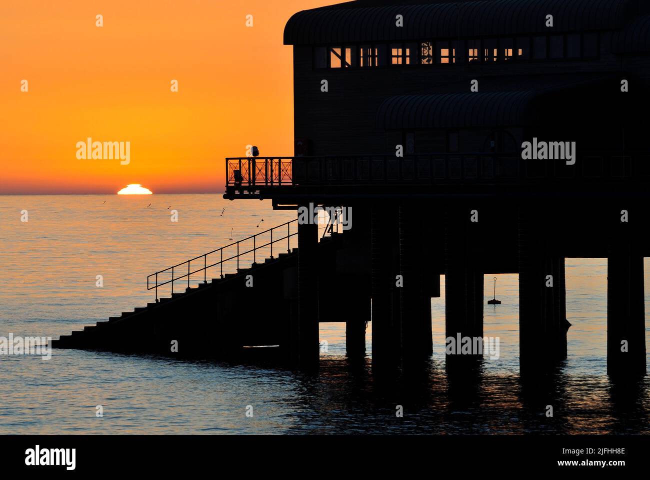 Midsummer sunrise, beside Cromer pier, Norfolk, England, UK Stock Photo