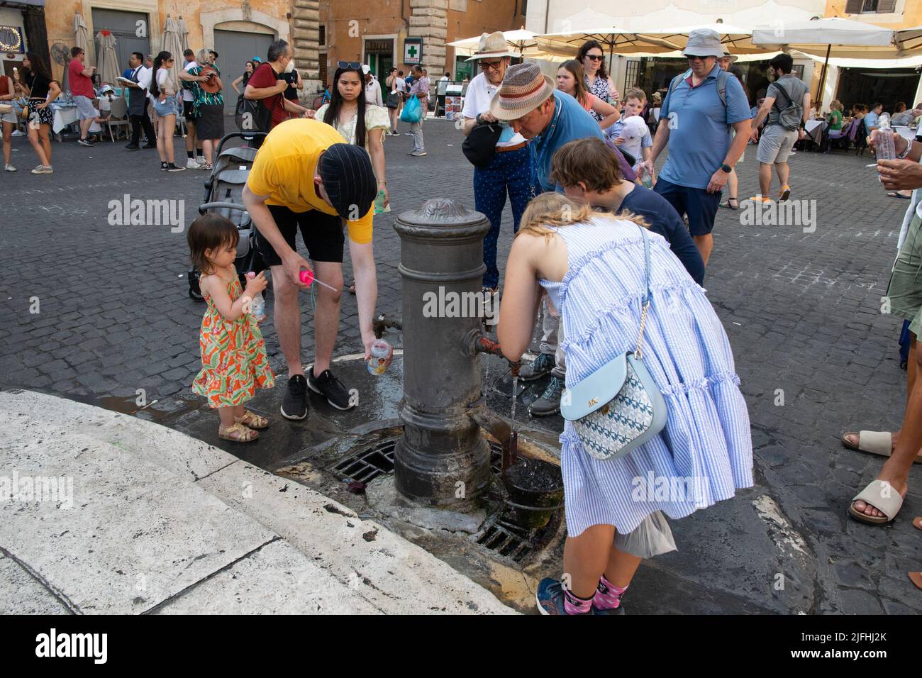 Rome, Italy, July 3th, 2022: People taking water from a street dispenser in the square in fron of the roman Parthenon, as extreme heat of 37-39° C affceted the city Credit: Christian Creixell/Alamy Live News Stock Photo
