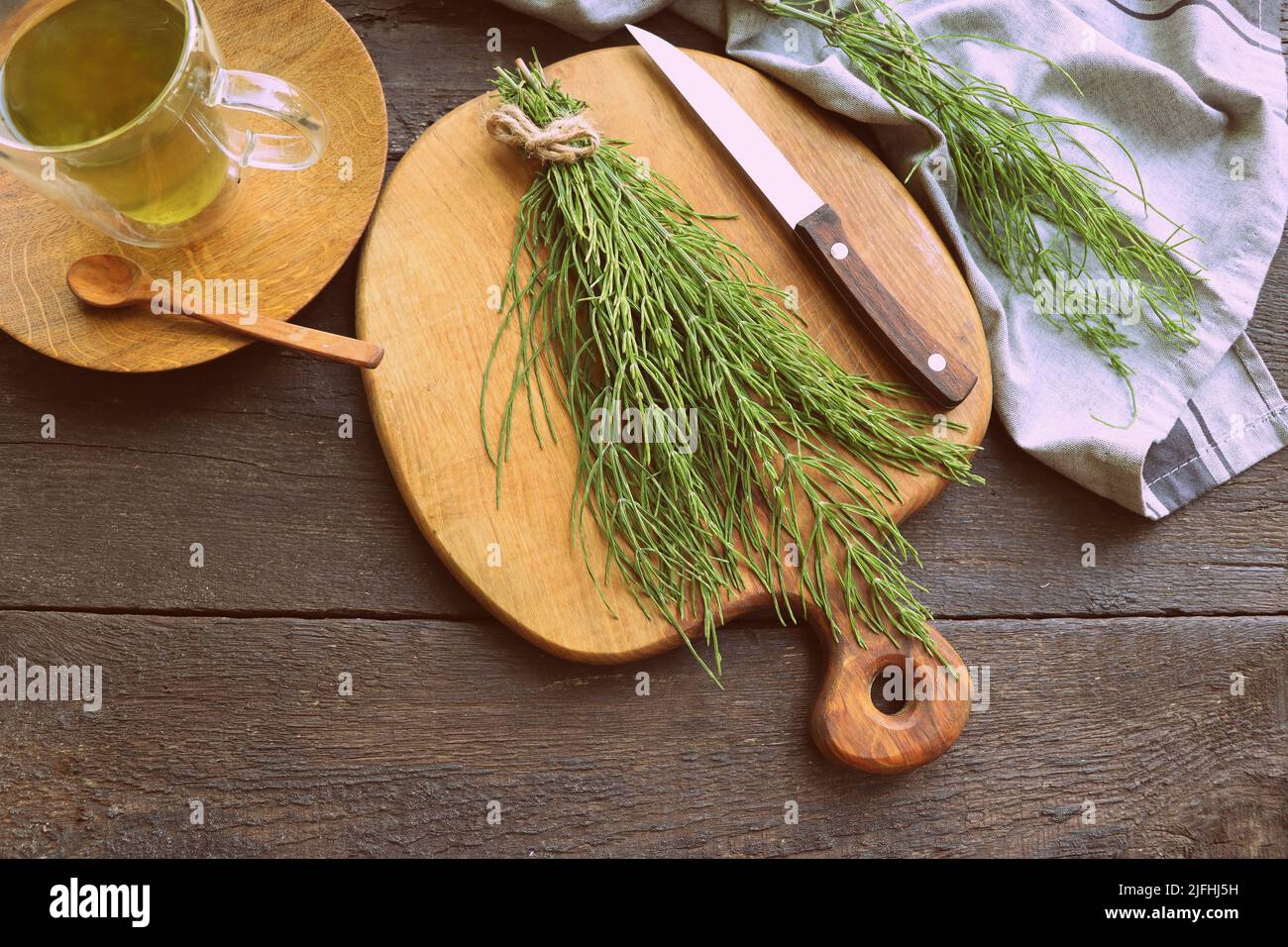 Fresh horsetail plant on a table with herbal tea on the wooden background Stock Photo