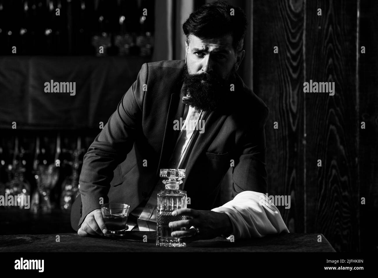 Alcohol concept. Bearded barmen, barkeeper or bartender in bar. Man with beard and mustache, vintage retro design Stock Photo